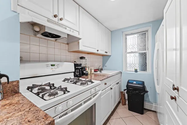 a kitchen with a stove a sink and a cabinets