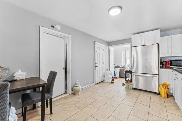 a kitchen with a refrigerator a table and chairs