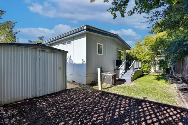 a backyard of a house with table and chairs
