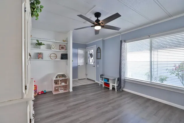 a view of a livingroom with wooden floor and a ceiling fan