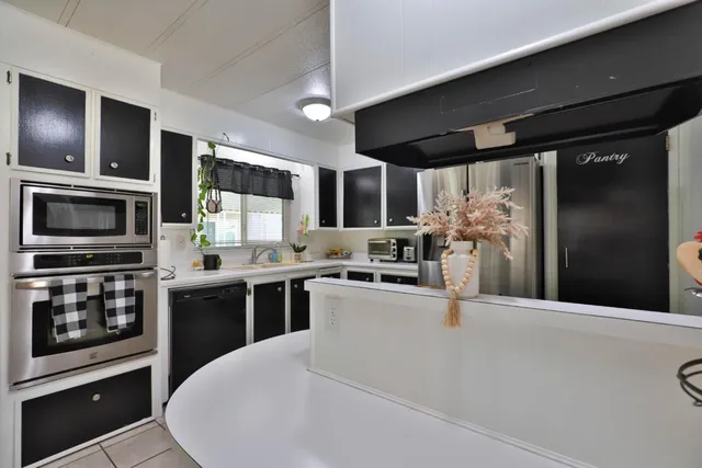 a kitchen with stainless steel appliances kitchen island granite countertop a refrigerator a stove top oven a sink and dishwasher