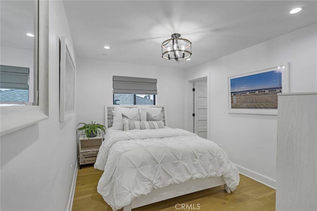 845 4th Street Hermosa Beach, CA 90254 - Photo 17 of 26 a bedroom with a bed and a chandelier