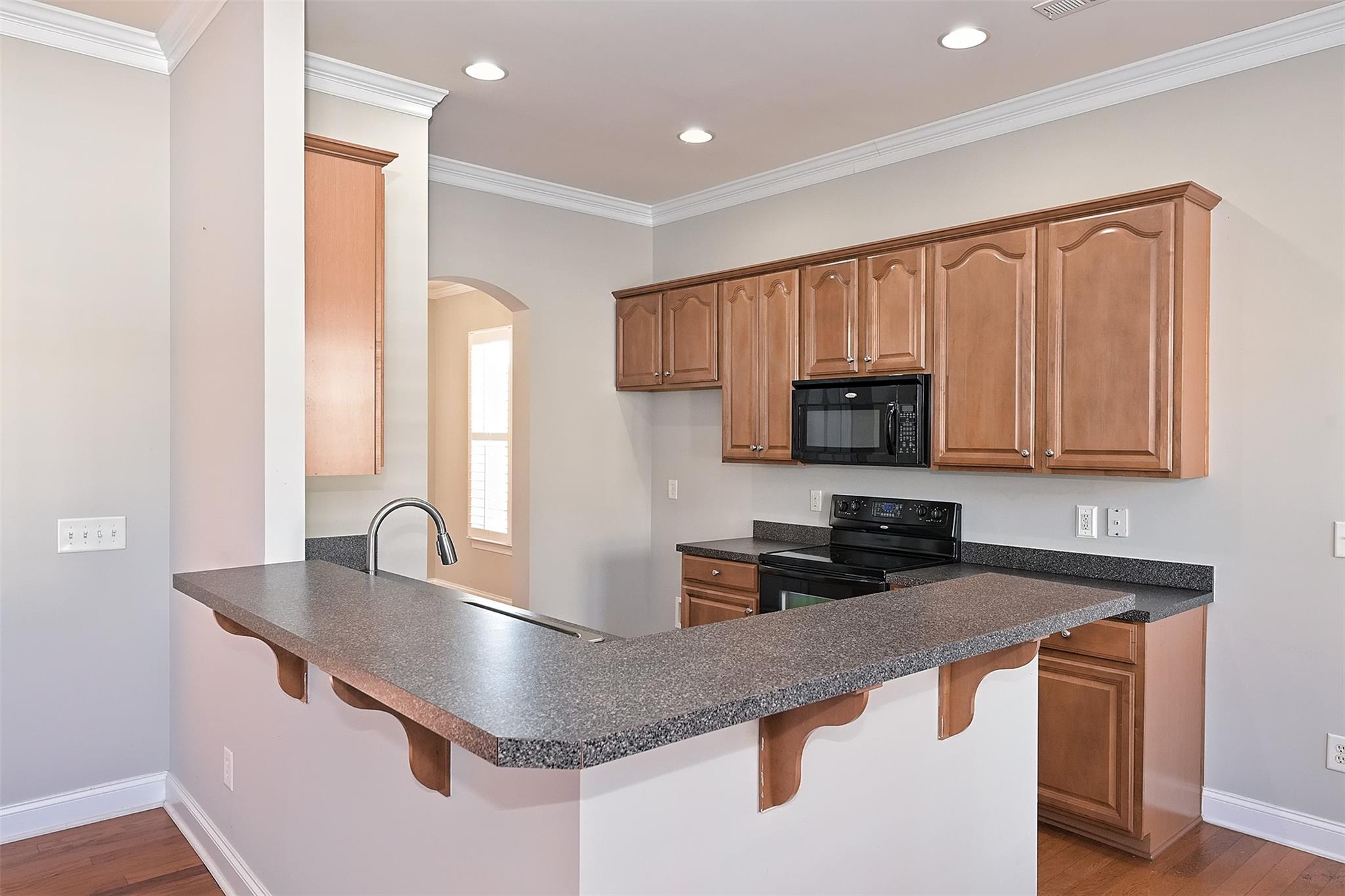 10725 Serape Road Charlotte, NC 28277 - Photo 11 of 30 a kitchen with stainless steel appliances granite countertop a sink a microwave and wooden cabinets