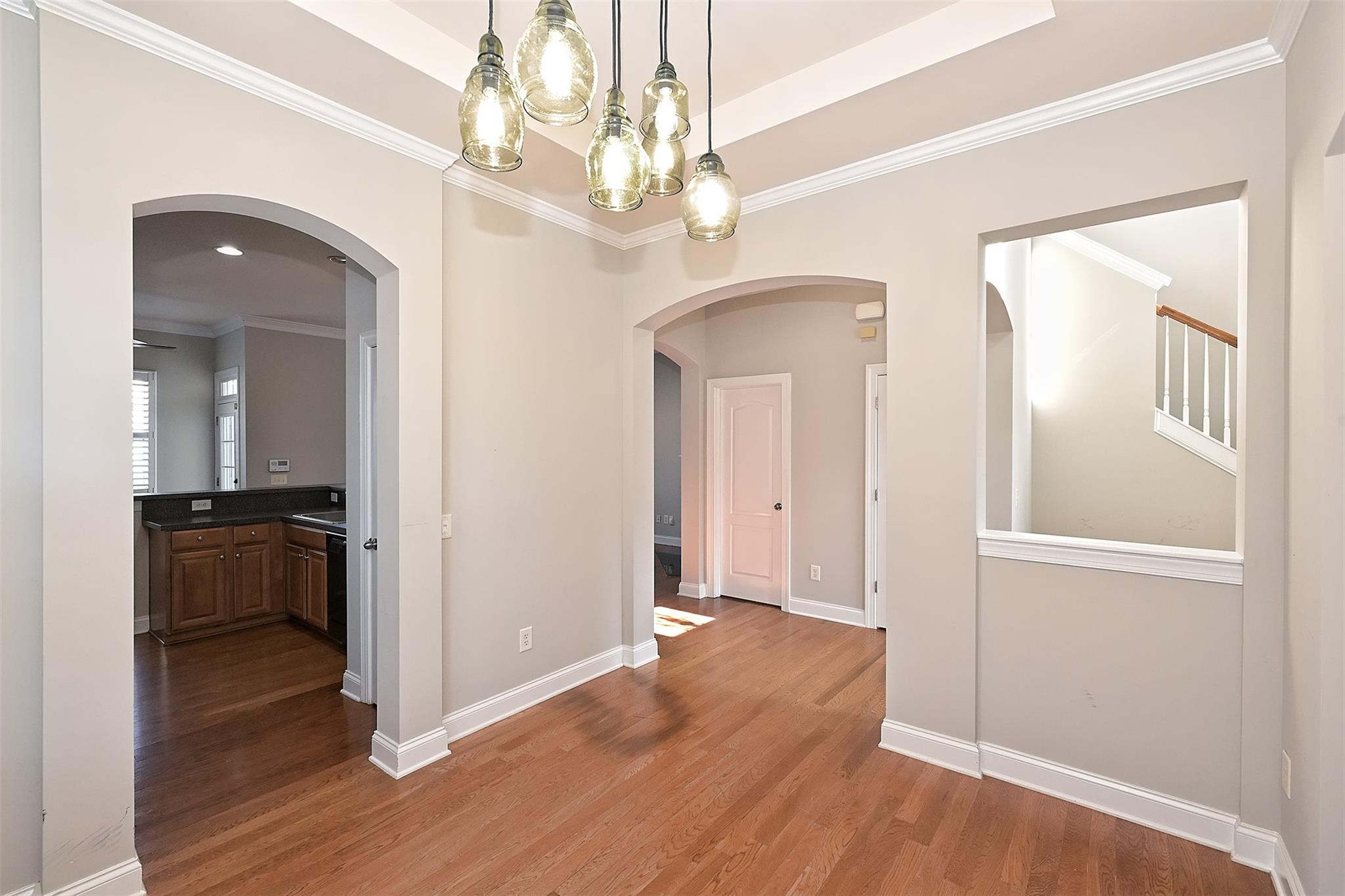 10725 Serape Road Charlotte, NC 28277 - Photo 7 of 30 a view of a hallway with wooden floor and a chandelier