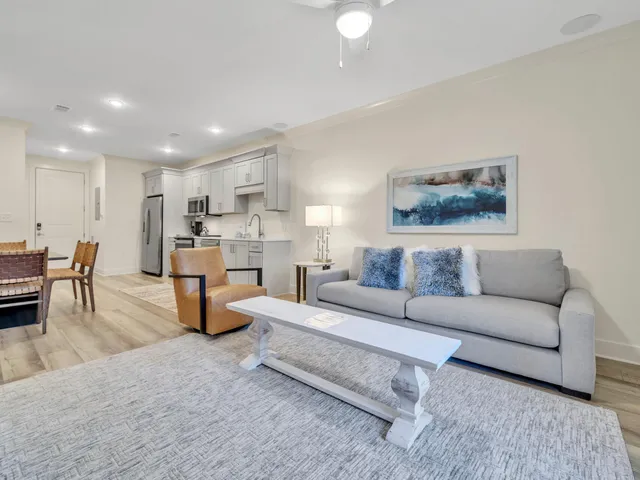 a living room with furniture and a dining table with kitchen view