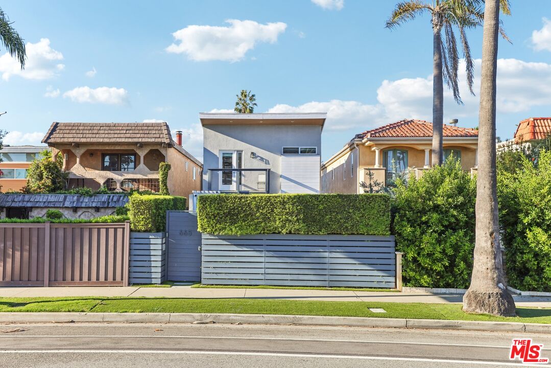 a front view of a house with a garden and plants