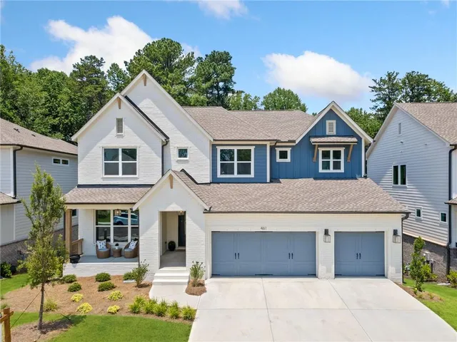 a front view of a house with a garden and mountain view