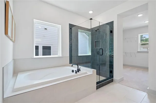 a spacious bathroom with a tub shower and sink