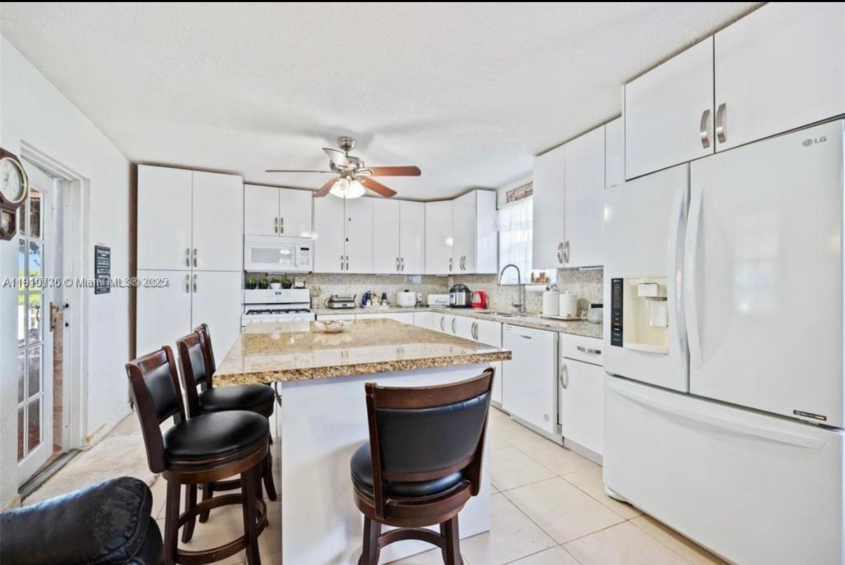 20235 Southwest 172nd Avenue Miami, FL 33187 - Photo 24 of 30 a kitchen with stainless steel appliances granite countertop a white cabinets and a refrigerator