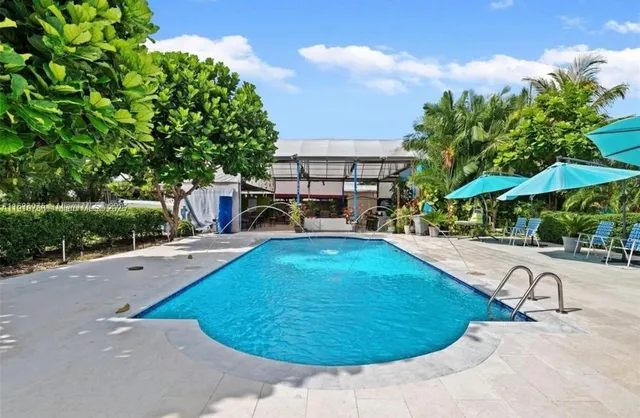 a view of a swimming pool with a patio and a yard