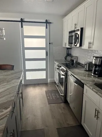 a kitchen with stainless steel appliances granite countertop a stove microwave and sink
