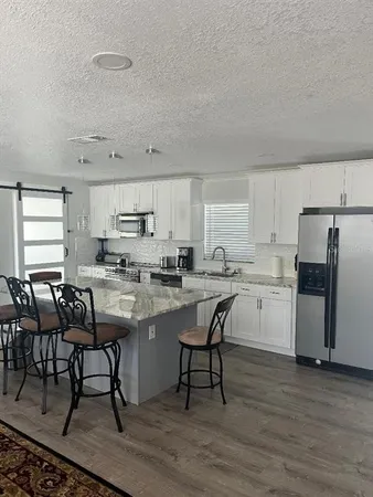 a kitchen with a table chairs microwave and cabinets