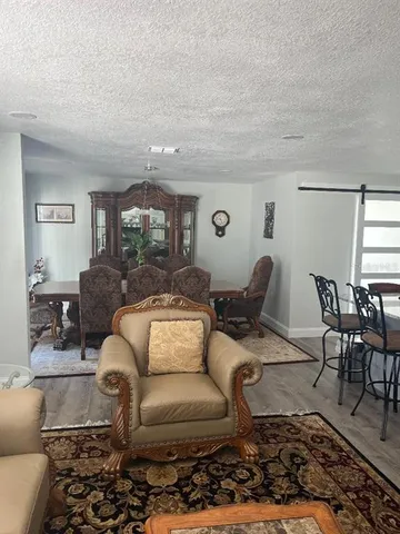 a living room with furniture and view of kitchen