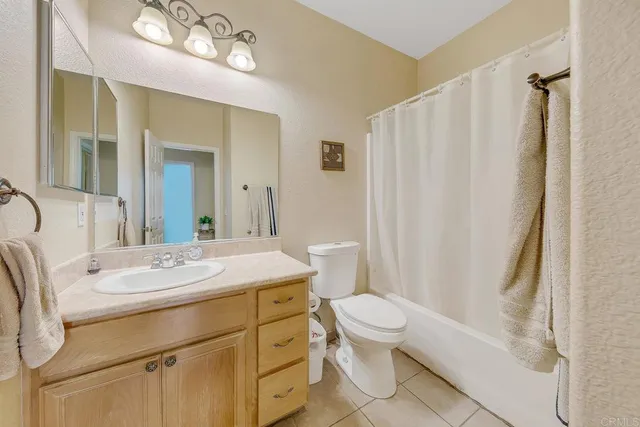 a bathroom with a sink a toilet a mirror and shower