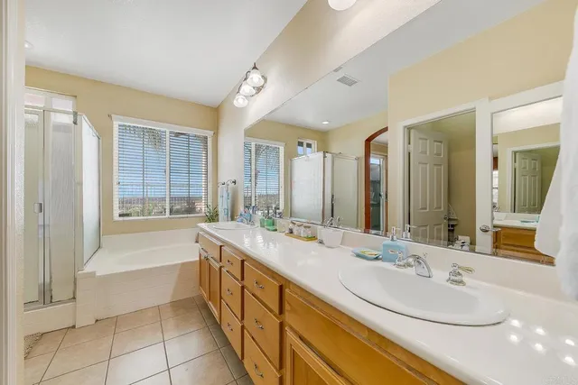 a bathroom with a granite countertop sink mirror and a bathtub