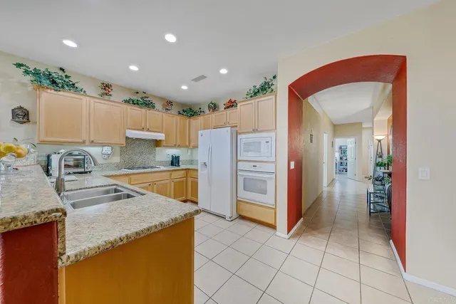 a kitchen with stainless steel appliances granite countertop a refrigerator and a sink