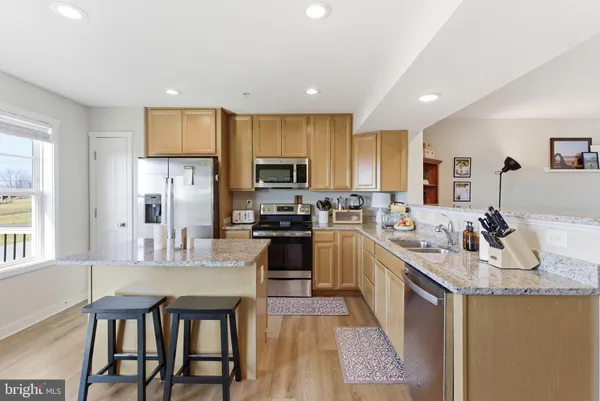 a large kitchen with kitchen island granite countertop lots of counter top space and stainless steel appliances