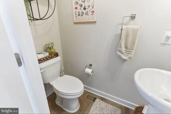a white toilet sitting next to a bathroom sink and a mirror