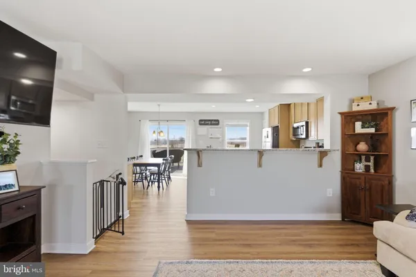 a view of a living room and kitchen with furniture and wooden floor