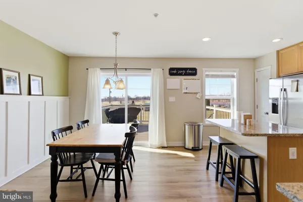 a dining room with furniture a chandelier and wooden floor