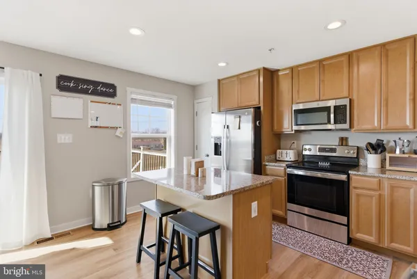 a kitchen with stainless steel appliances granite countertop a refrigerator stove microwave and sink