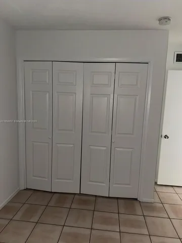 a view of a small space with wooden floor and a window