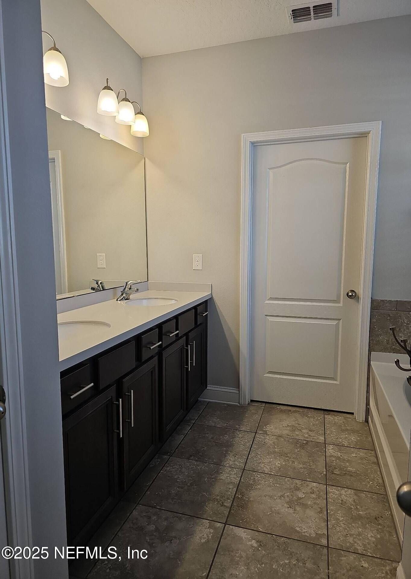 61 Boulder Rock Way St. Augustine, FL 32092 - Photo 9 of 20 a bathroom with a sink a toilet a mirror and vanity
