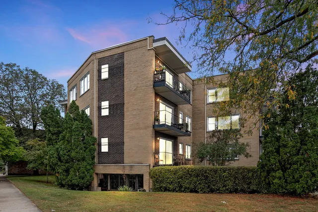 a front view of a residential apartment building with a yard