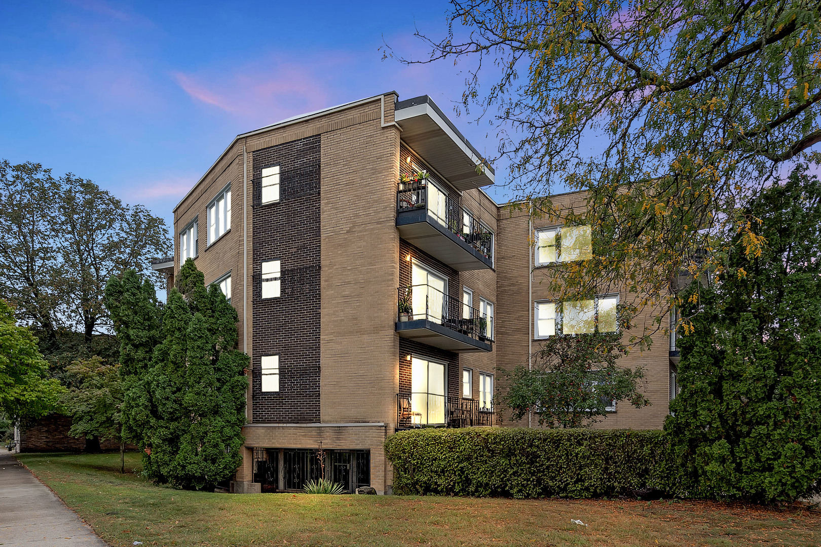 a front view of a residential apartment building with a yard