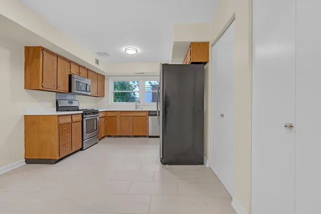 a kitchen with stainless steel appliances a refrigerator and a stove top oven