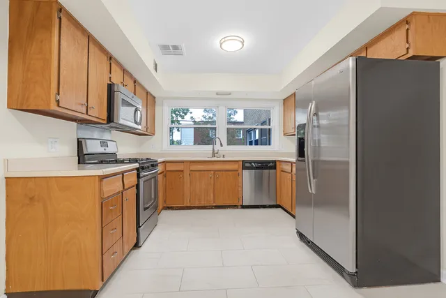 a kitchen with stainless steel appliances granite countertop a stove a sink dishwasher a refrigerator and a refrigerator