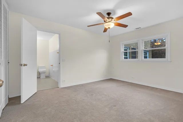 a view of an empty room with a ceiling fan and a ceiling fan