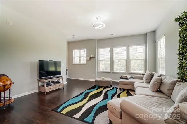 a living room with furniture flat screen tv and wooden floor
