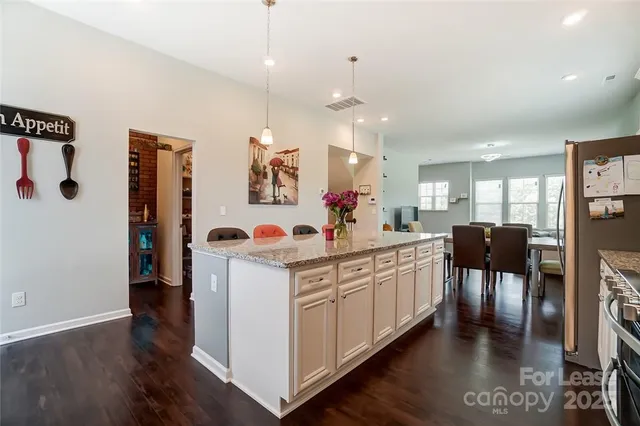 a large white kitchen with lots of counter space and furniture