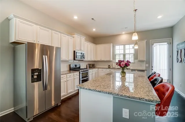a kitchen with granite countertop a refrigerator a stove a sink and dishwasher