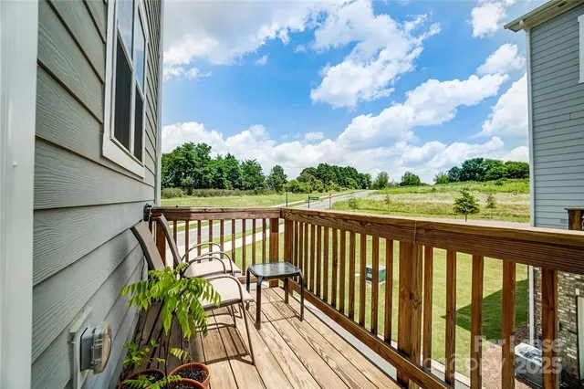 a view of balcony with wooden floor & fence