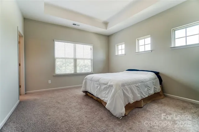 a bed sitting in a bedroom next to a window