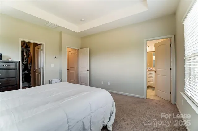 a bed room with a bed and a view of kitchen
