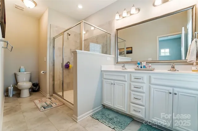 a bathroom with a double vanity sink mirror and toilet