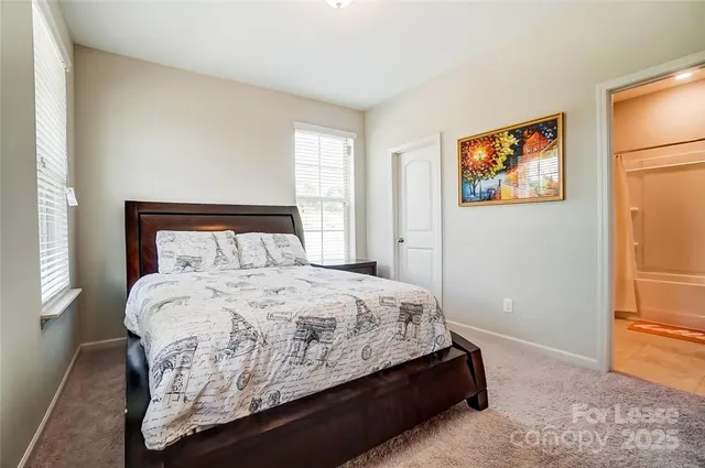 a bedroom with a bed and painting on the wall