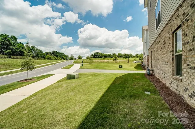 a view of yard with swimming pool and trees in the background