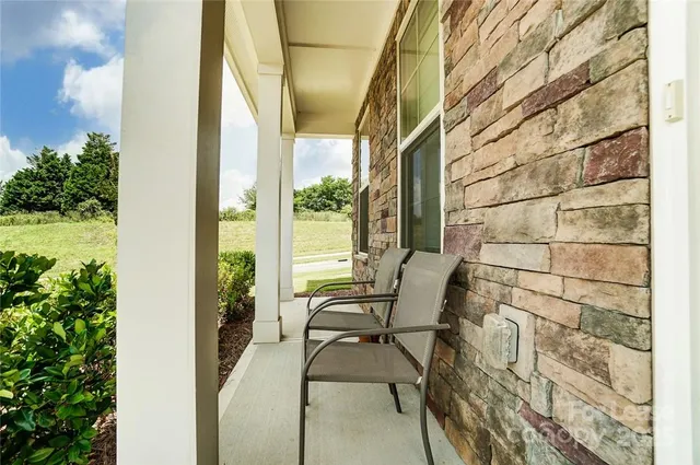 a patio with table and chairs and potted plants