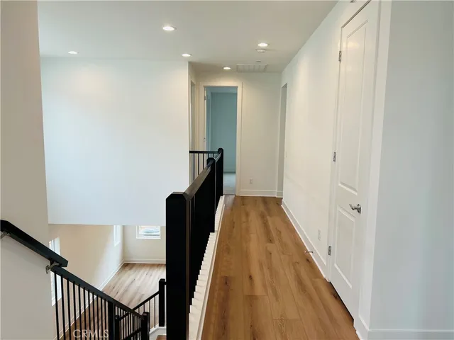 a view of hallway with stairs and wooden floor