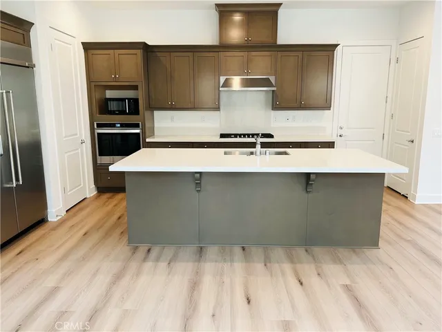 a kitchen with stainless steel appliances a sink stove and refrigerator