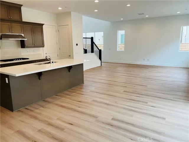 a large kitchen with stainless steel appliances a large counter top oven a sink and a refrigerator