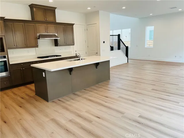 a large kitchen with stainless steel appliances granite countertop a sink counter space and wooden floor