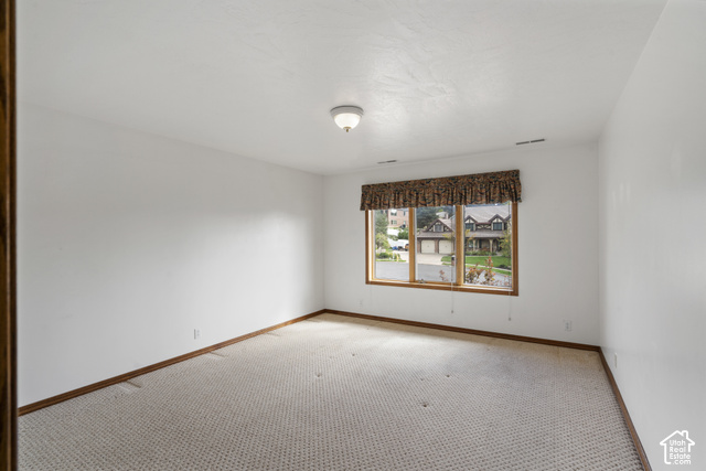 1373 Pheasant Ridge Circle Bountiful, UT 84010 - Photo 33 of 50 Carpeted room with white walls, wood-finish trim, and a ceiling-mounted light fixture