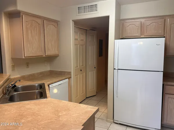a kitchen with a refrigerator sink and cabinets