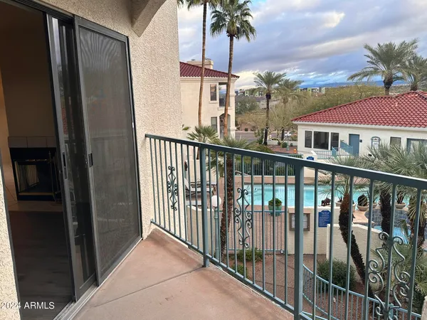 a view of a balcony with a floor to ceiling window and potted plants