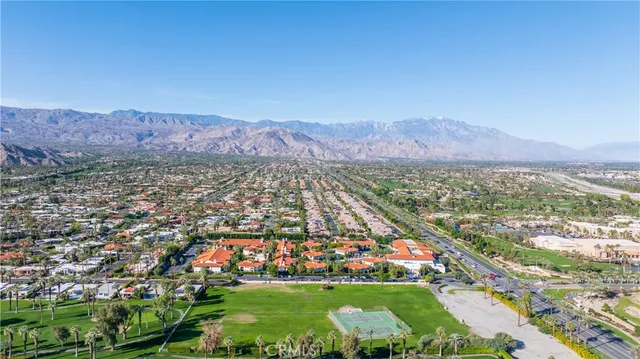 an aerial view of residential houses with outdoor space and trees